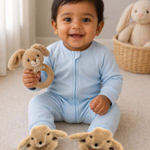 baby wearing brown bunny booties and holding a bunny rattle