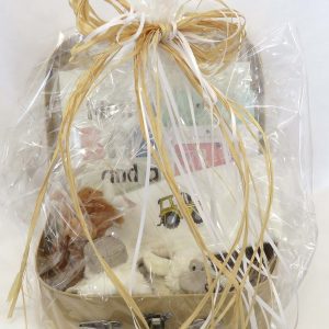 Small hamper for babies wrapped in cellophane with raffia and white ribbons