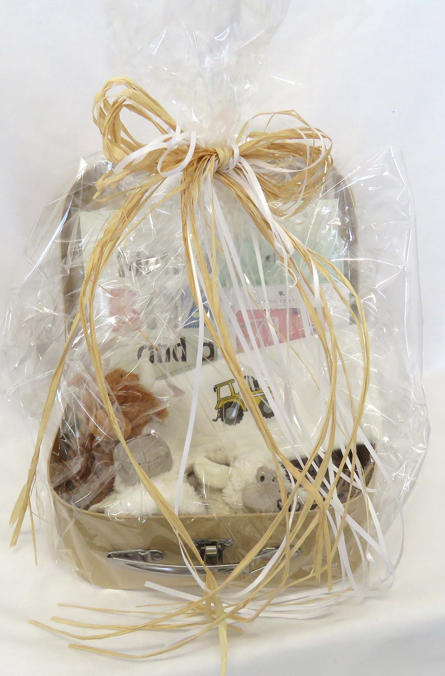Small hamper for babies wrapped in cellophane with raffia and white ribbons