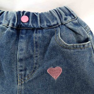 blue sweetheart denim jeans close up of front pocket, heart detail, and pink button