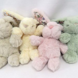 group of four plush bunnies all with floral ears in beige, yellow, pink, or green