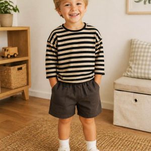 a boy wearing a kids on trend striped black t-shirt and grey shorts