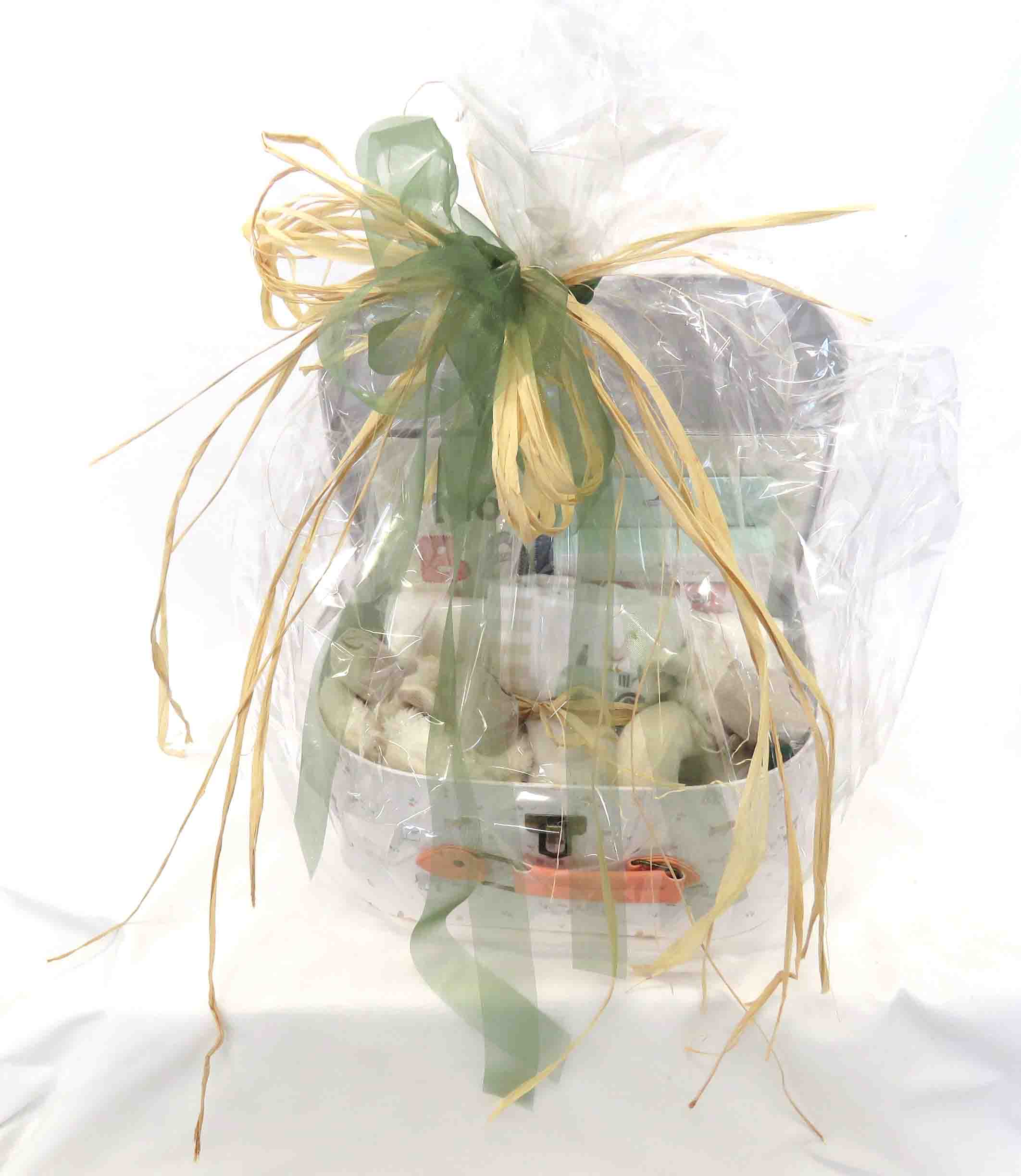 Medium sized baby hamper wrapped in cellophane with raffia and green ribbon