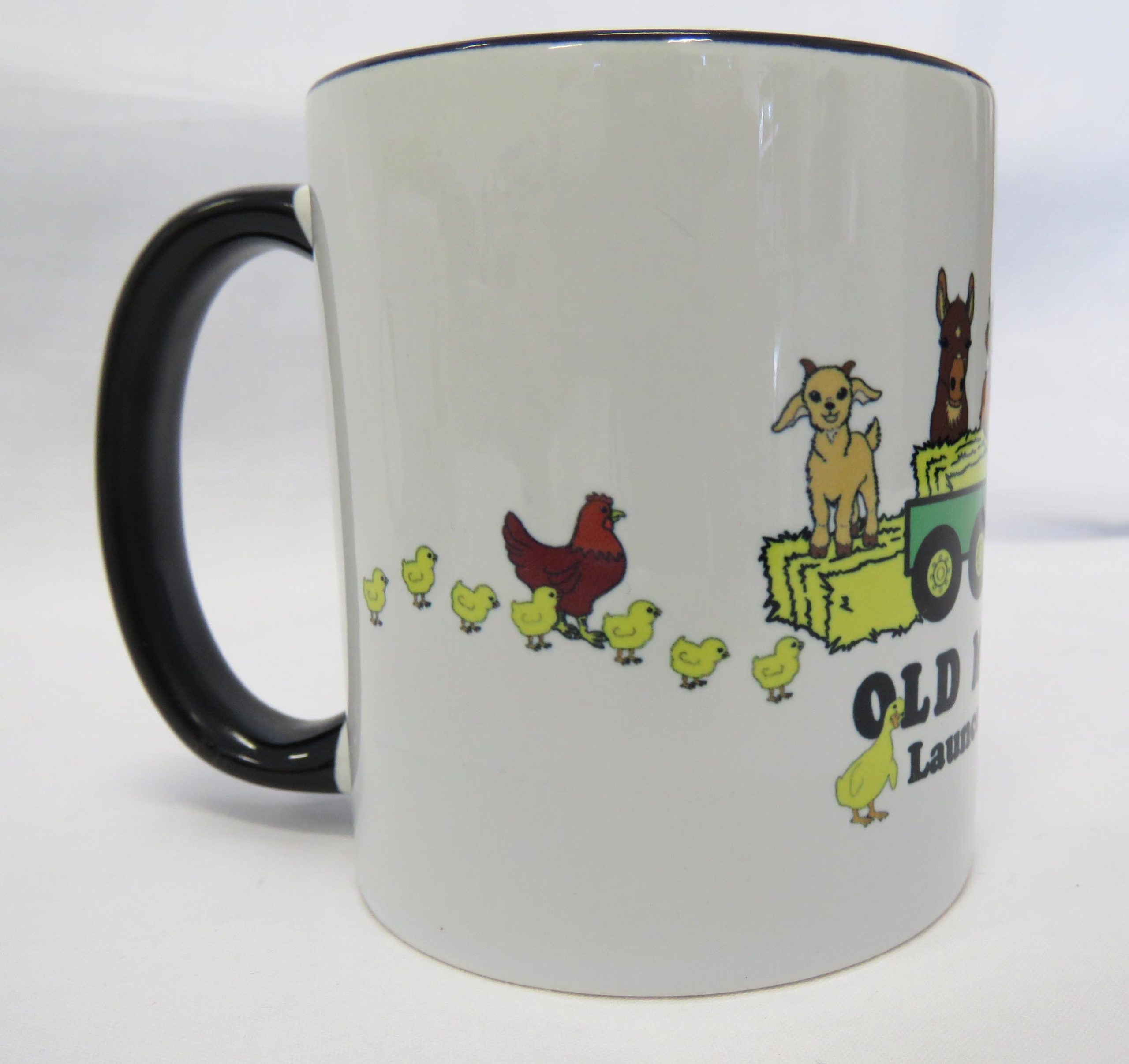 old macs coffee mug with black handle and cartoon style green tractor and animals side view 2